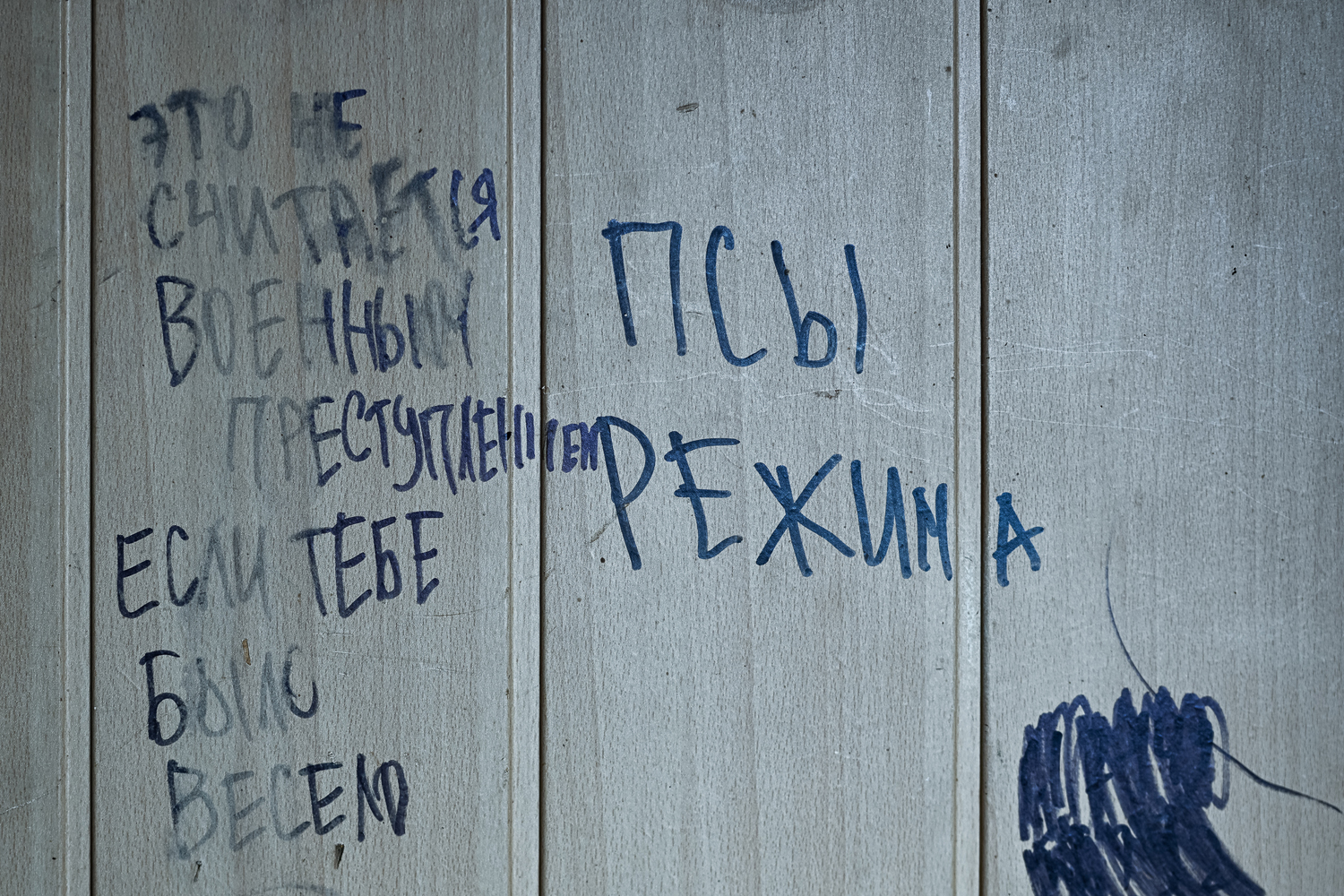 a wall with a Russian-language inscription saying: “it’s not a war crime if you had fun”